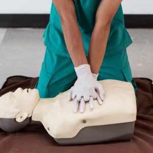 A person performing CPR on a mannequin